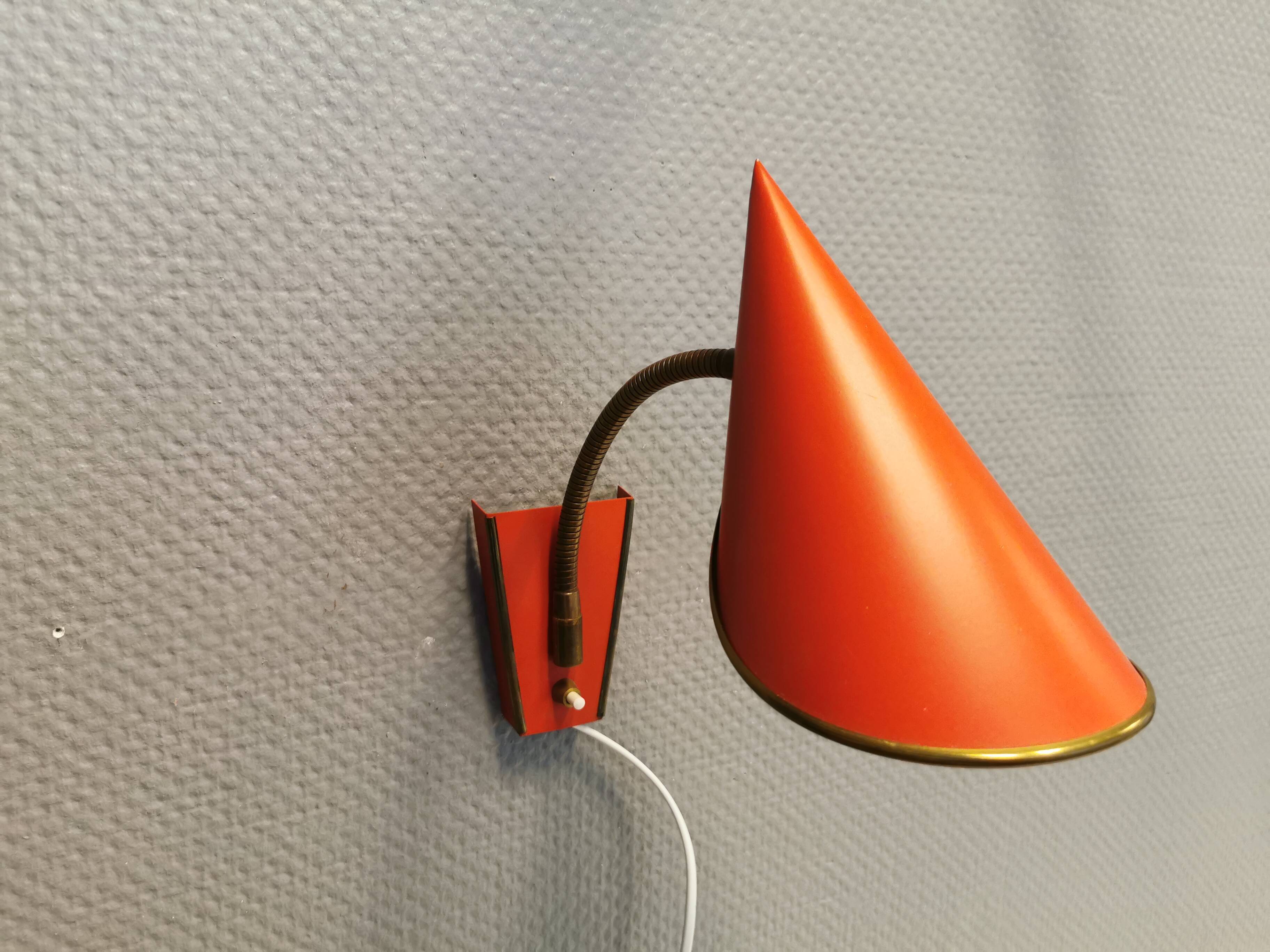 Danish red lacquered wall light with brass details. Estimated 1980s