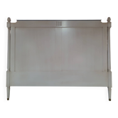 White headboard in Napoleon style with brass feet.