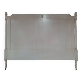 White headboard in Napoleon style with brass feet.