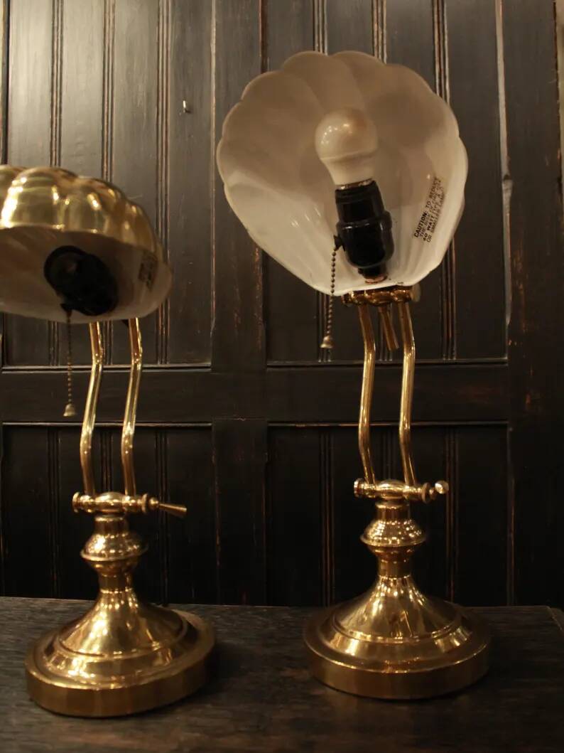 Pair of articulated brass lamps in the shape of a shell.