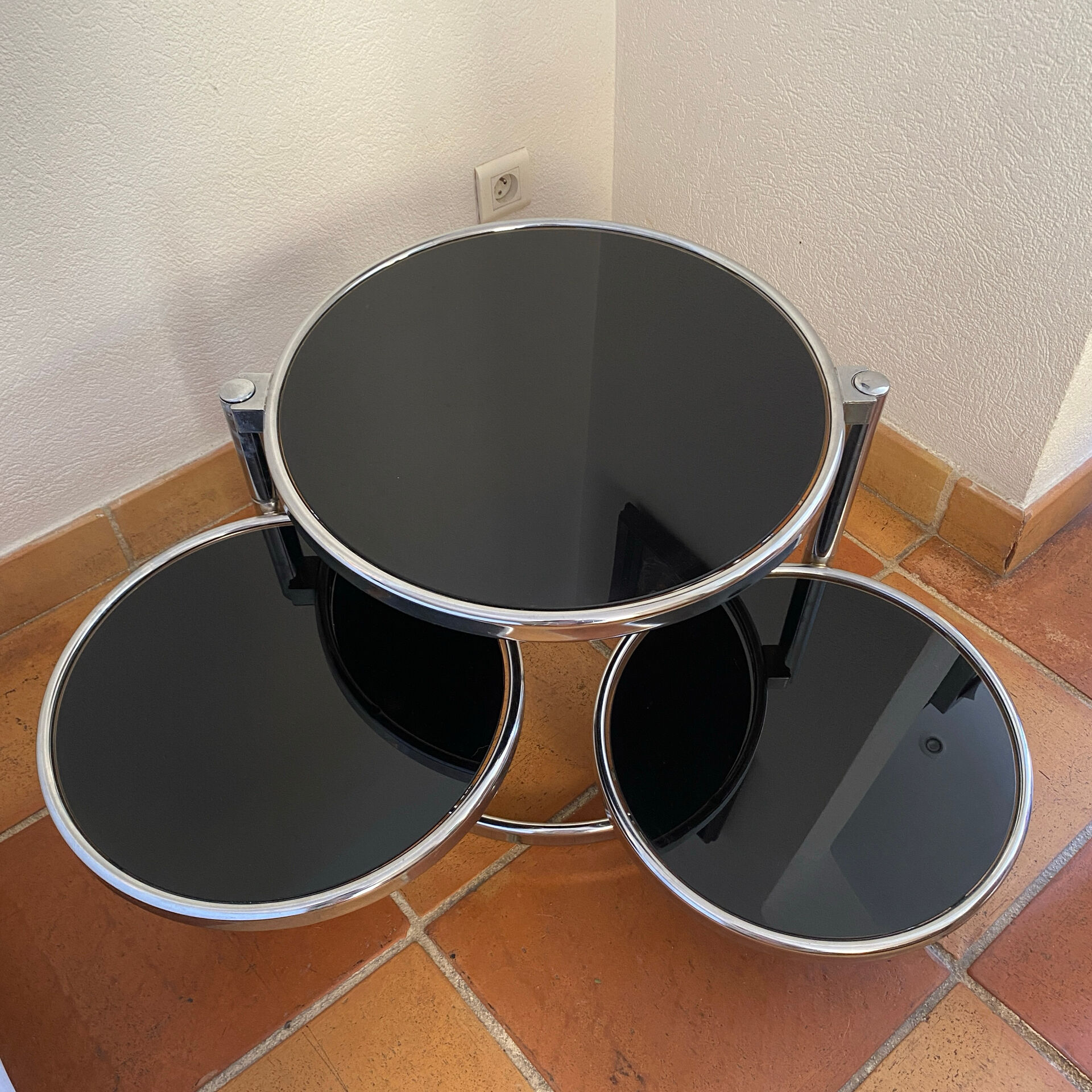 Coffee table with pivoting metal and black glass elements.