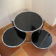 Coffee table with pivoting metal and black glass elements.