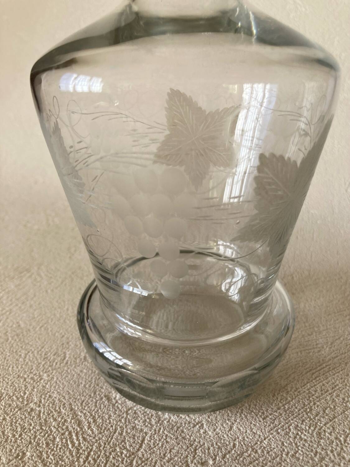 Small carafe in blown cut glass with engraved decoration of vine leaves and grapes, threaded stopper