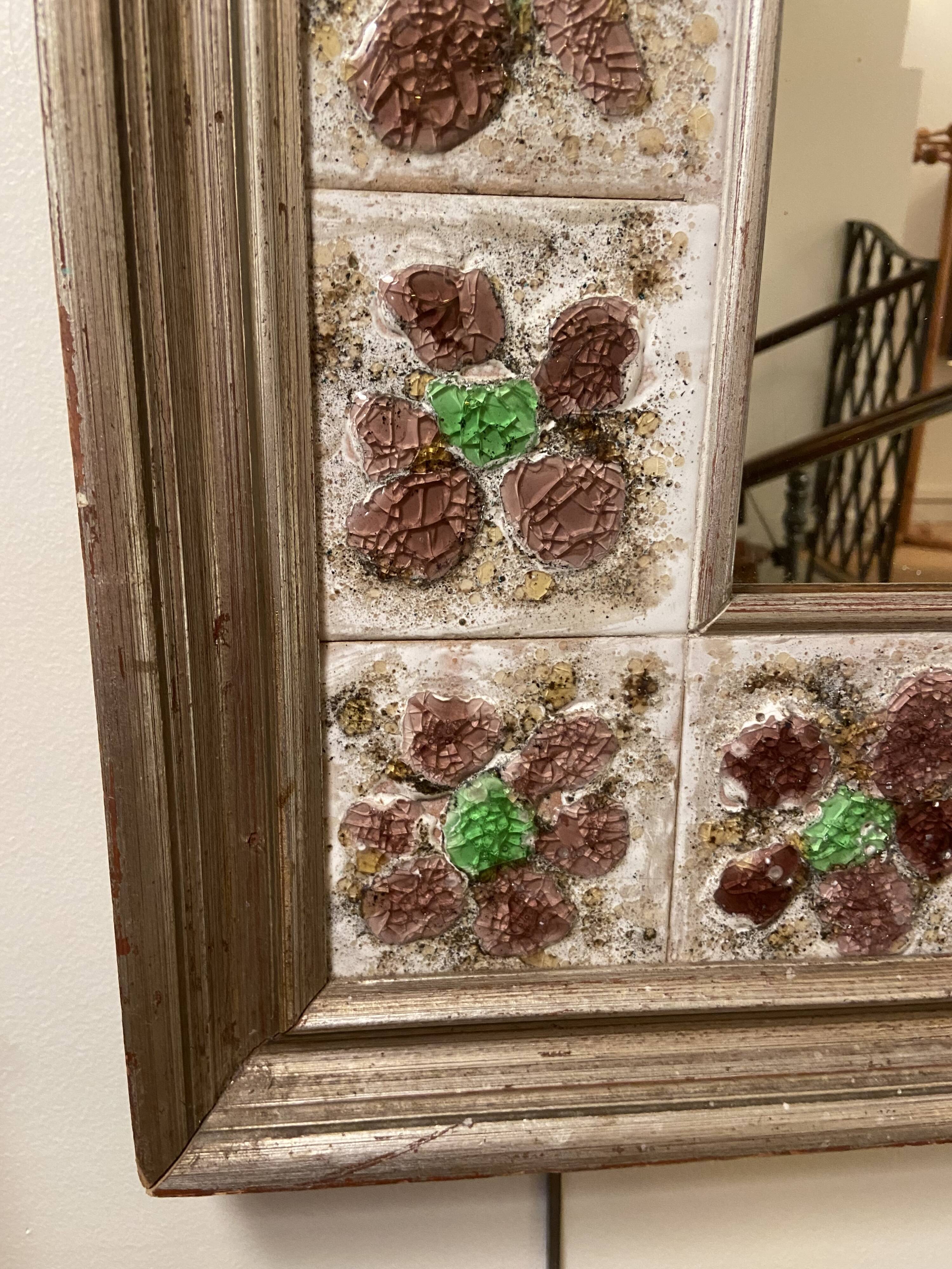 Large square ceramic mirror with floral decoration.