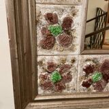 Large square ceramic mirror with floral decoration.