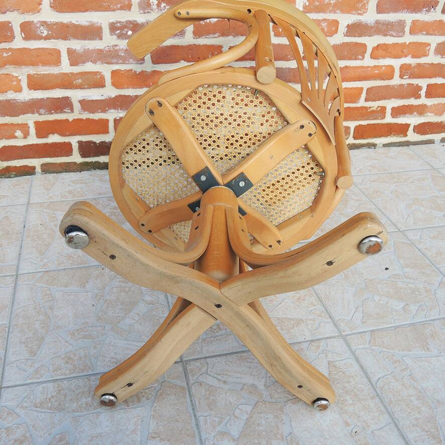 Vintage American swivel chair in wood and cane.
