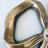 Bow-shaped brass trivet