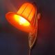 Art Deco wall light in brass with an orange globe.