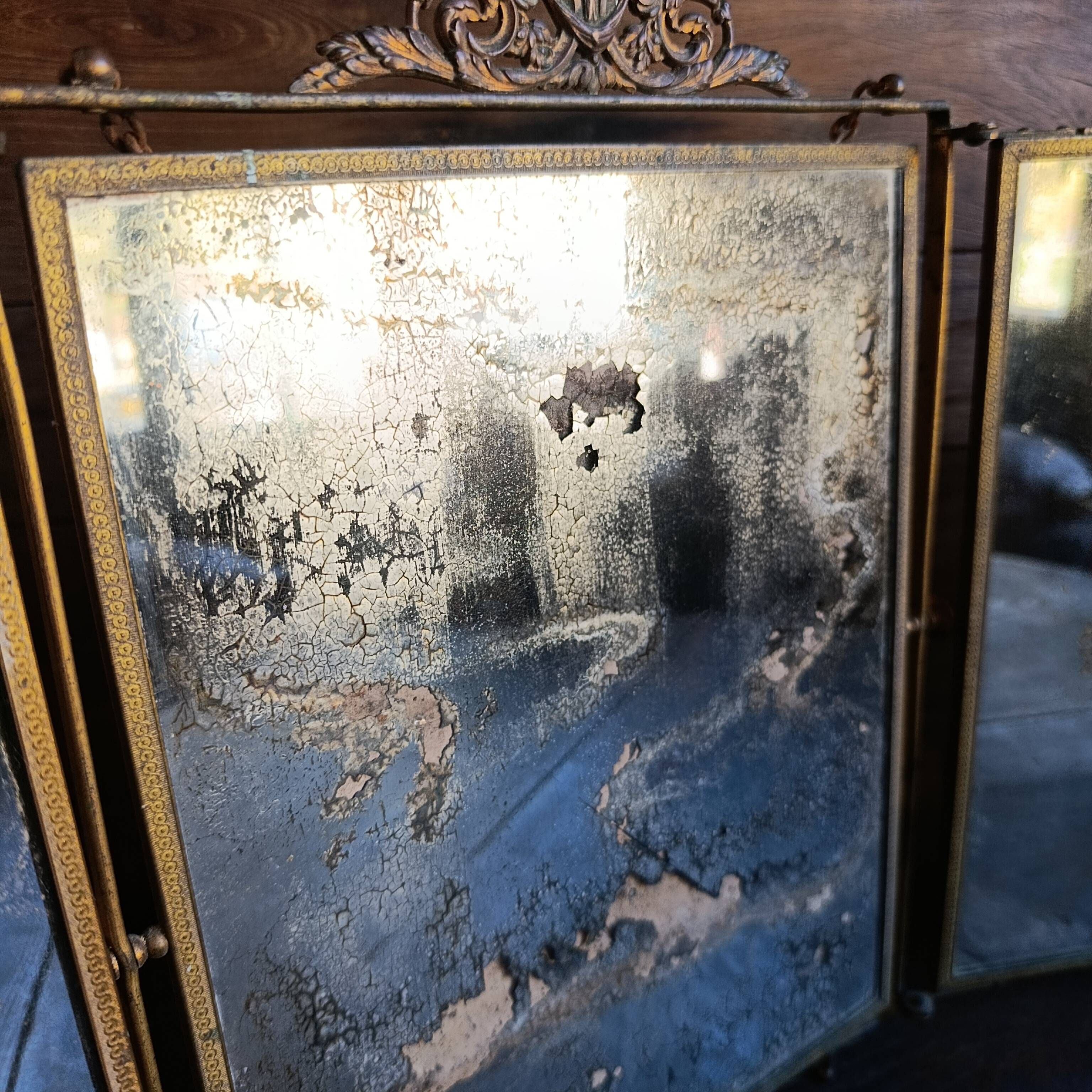Antique French gilt metal triptych vanity mirror with floral crest