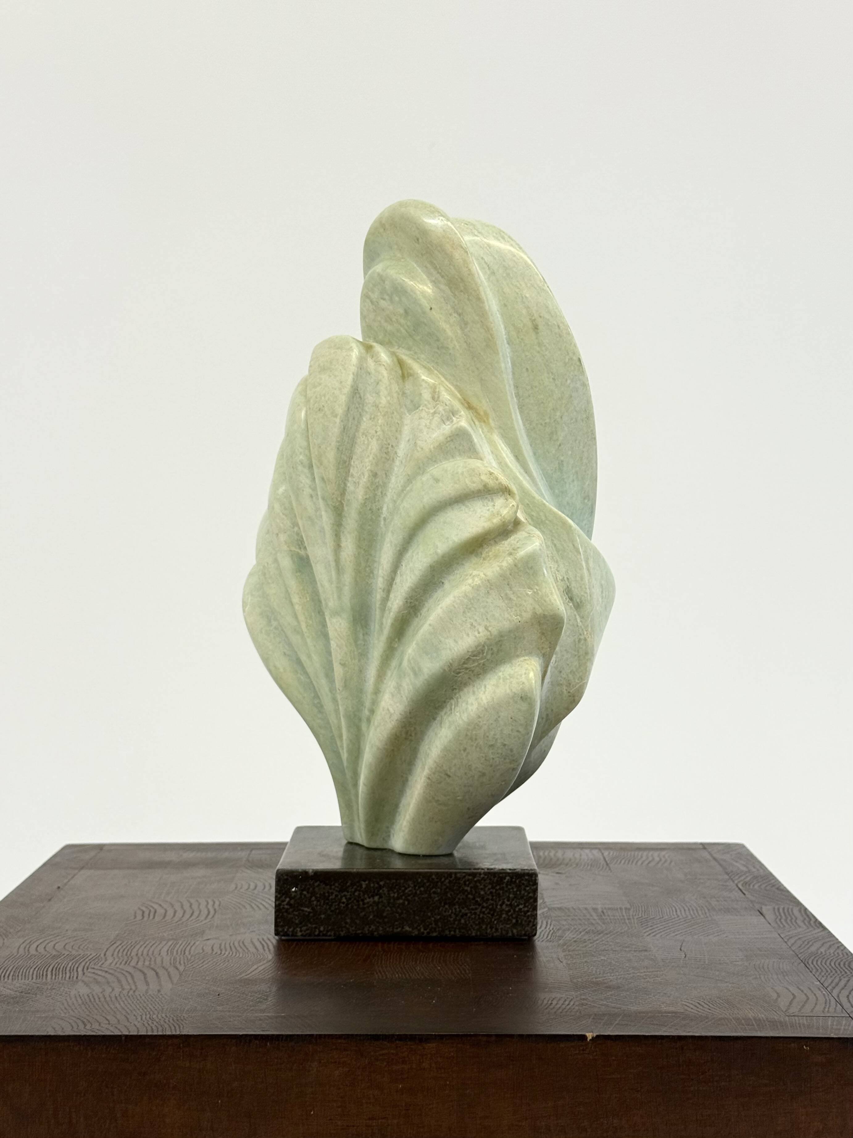 Green natural stone sculpture on marble base