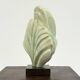 Green natural stone sculpture on marble base