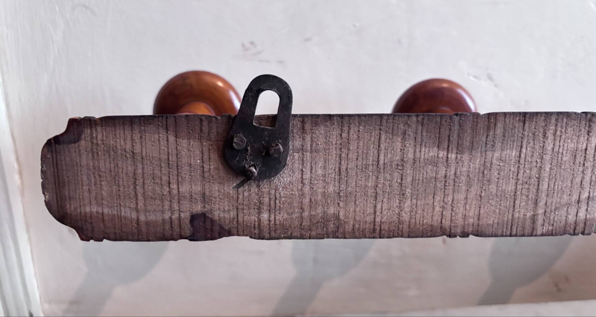 Wall-mounted coat rack with 8 turned wooden hooks in faux bamboo style.