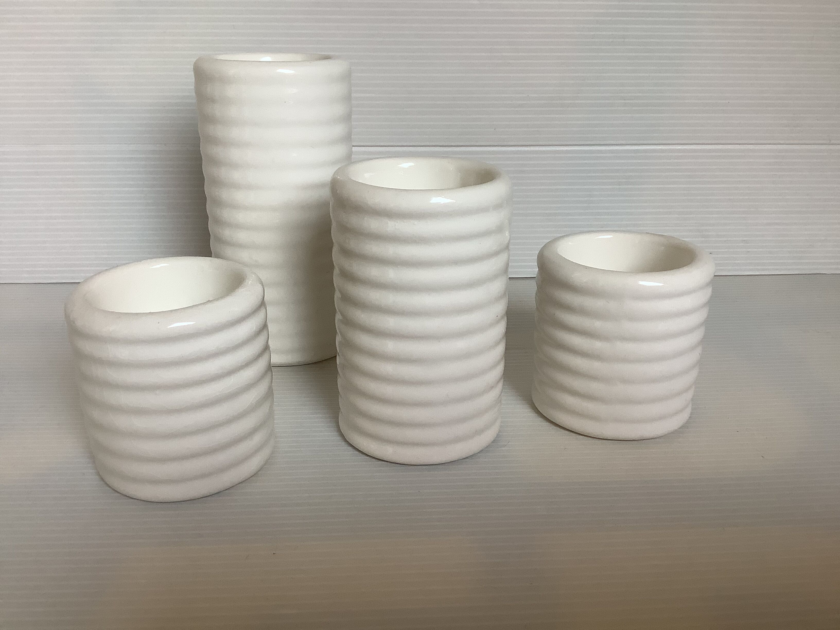 Four white earthenware candle holders