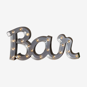 Enseigne lumineuse en lettrage aluminium formant le mot "bar"