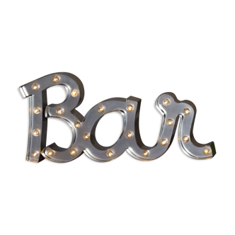 Enseigne lumineuse en lettrage aluminium formant le mot "bar"