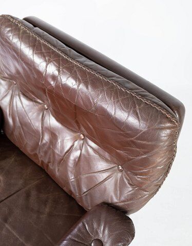 Easy chair upholstered with patinated brown leather and frame in metal, designed by Arne Norell