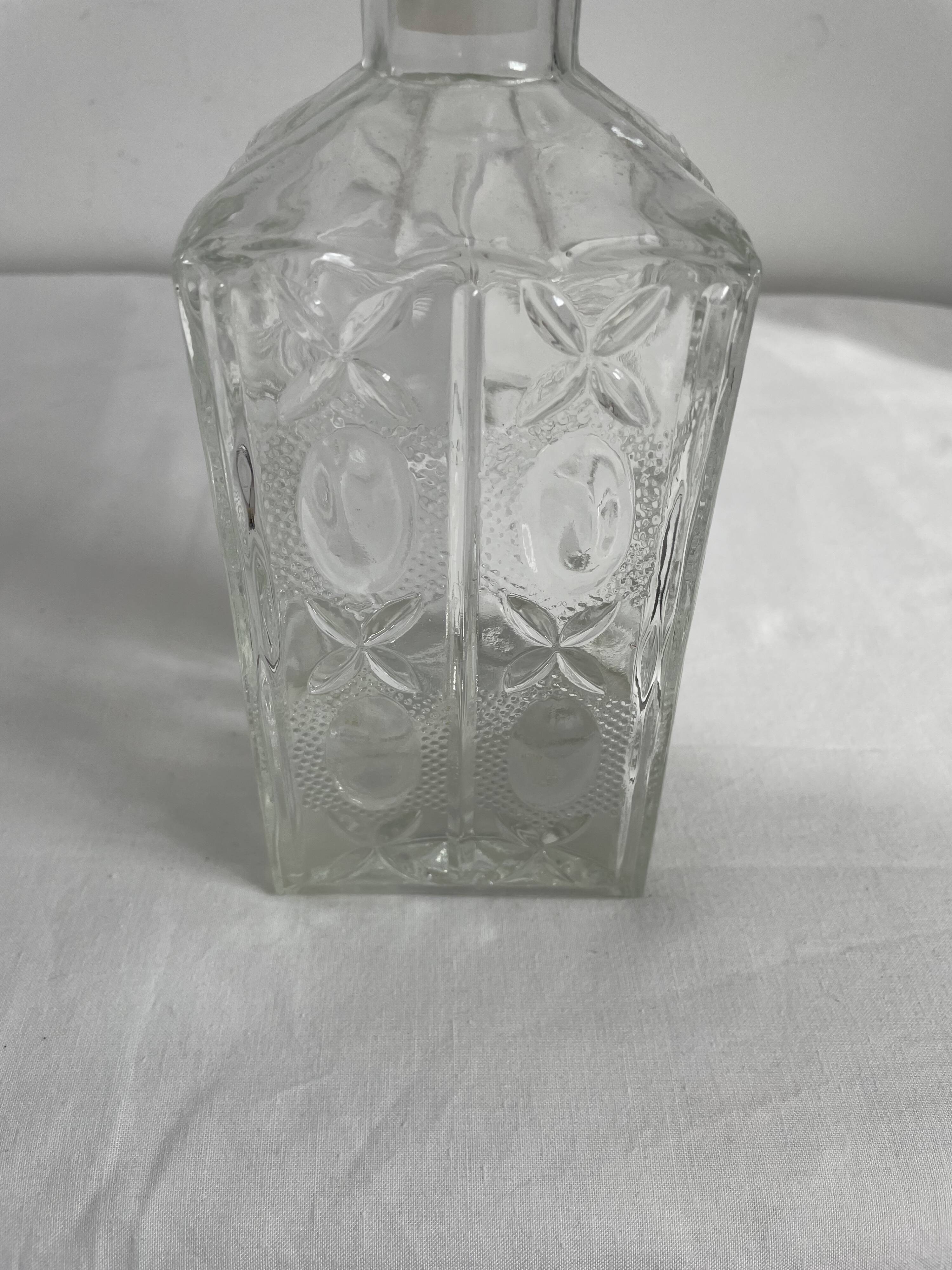 Molded glass carafe, 1960s-1970s, stylized flower decoration, oval, square base, stopper, rosette