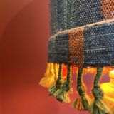 "Stoneware Bottle Lamp" with a multicoloured blue lampshade handwoven in India.