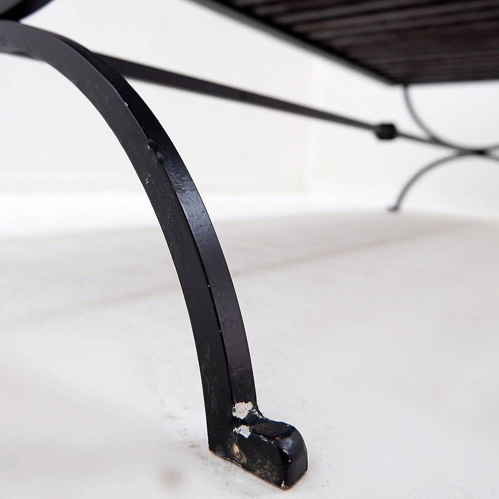 Solid wood coffee table with an openwork design and wrought iron legs.
