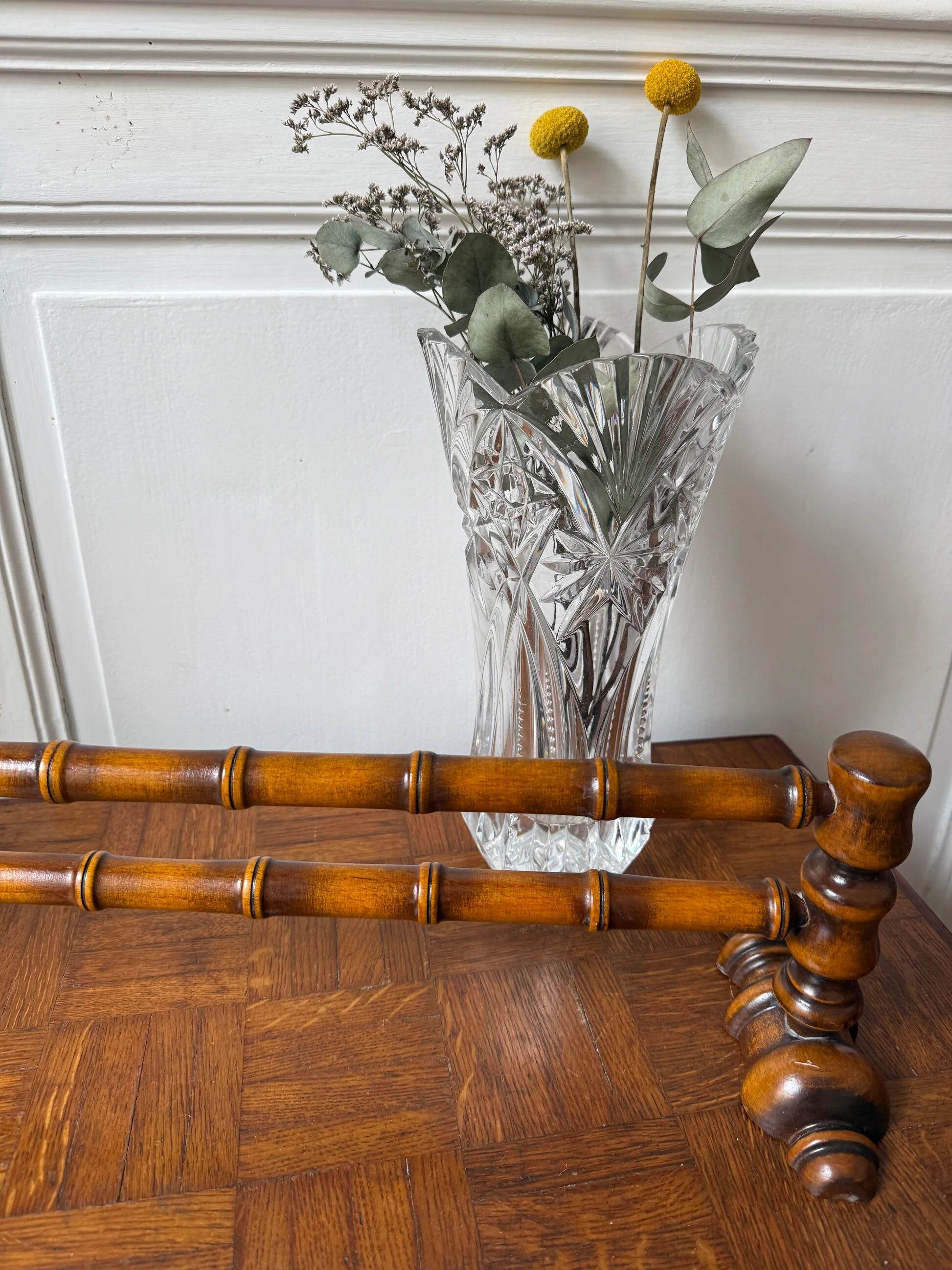 Wall-mounted coat rack made of turned wood in a bamboo style.