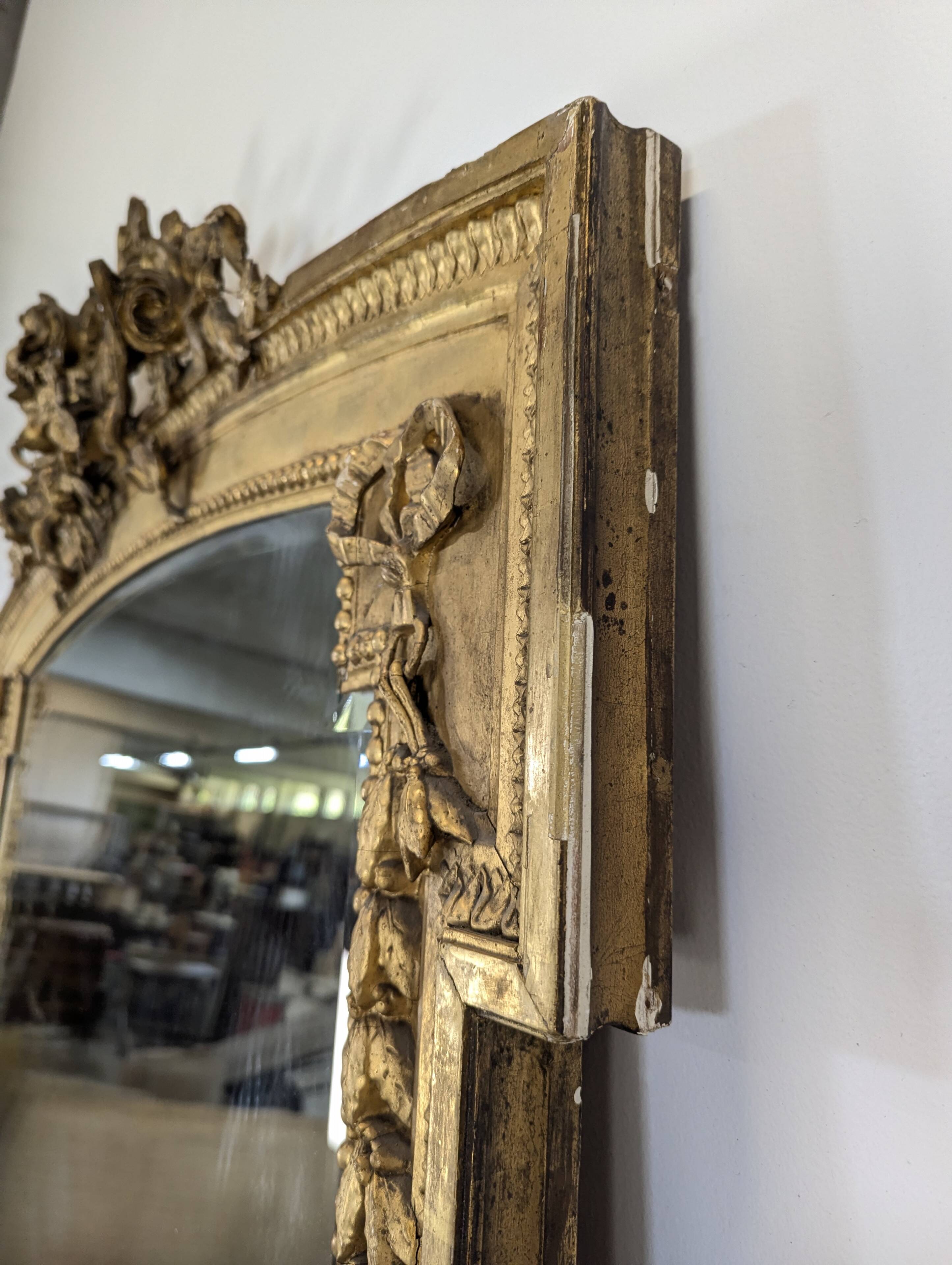 Large gilded wooden mirror in Louis XVI style from the late 19th century.