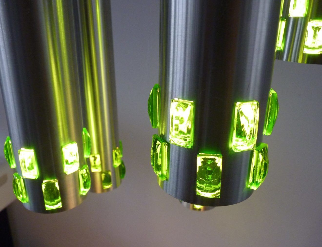 Suspension cascade of aluminum tubes with green glass