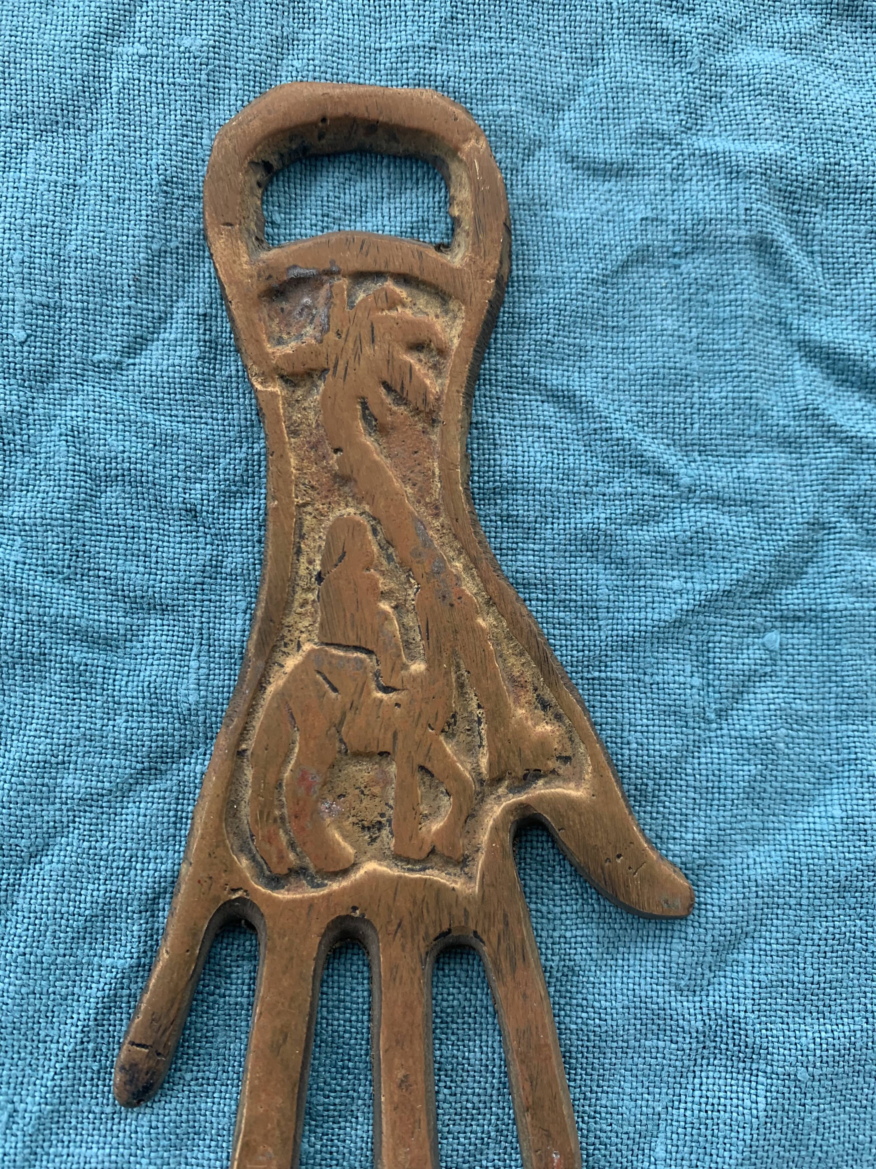 Two brass bottle openers in the shape of a chiseled hand vintage oriental décor