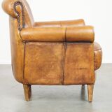 Comfortable, cozy armchair made of sheepskin leather with a proper finish with decorative nailheads