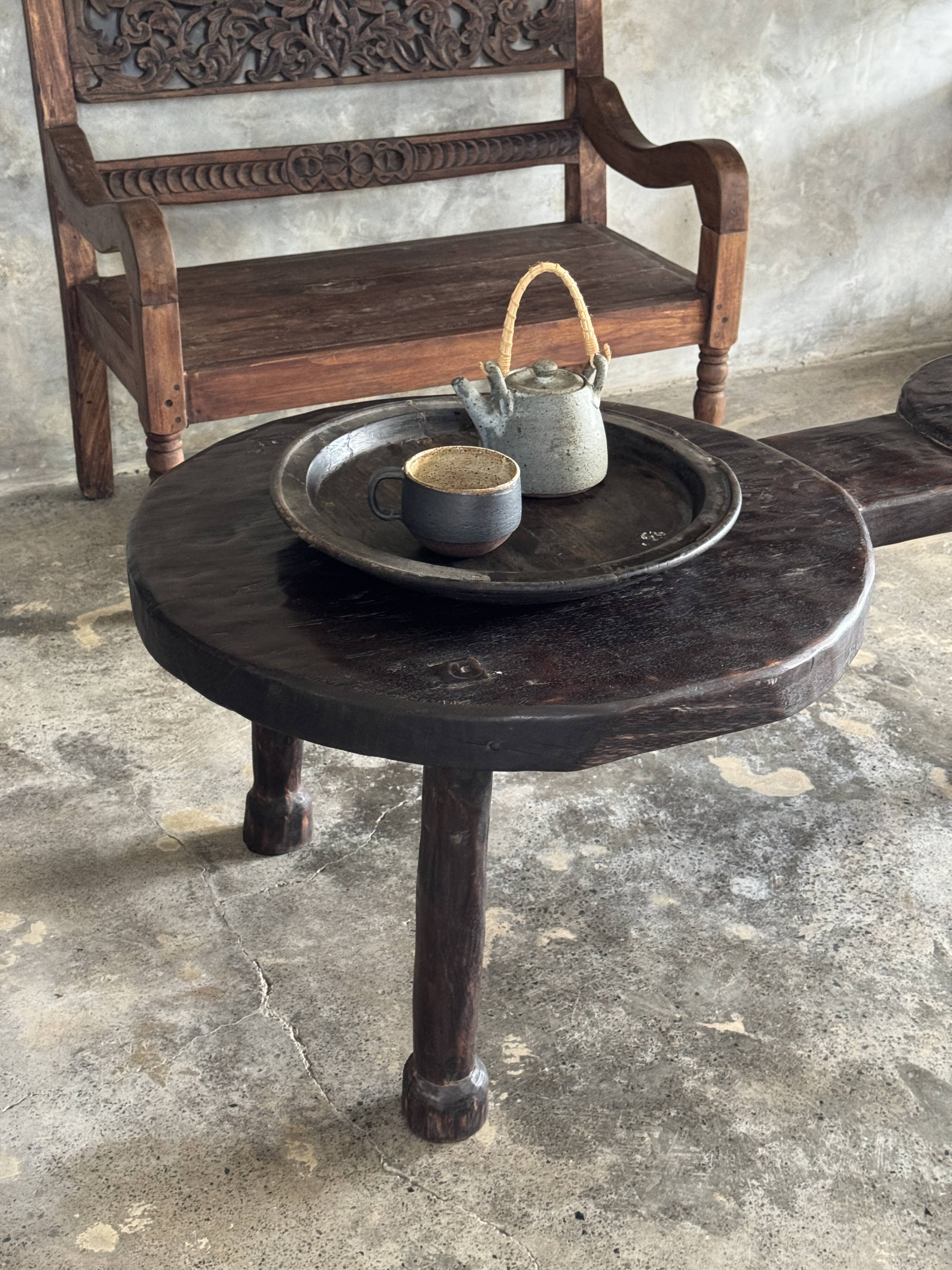 Small antique Indonesian bench in carved teak with plant and floral motifs.