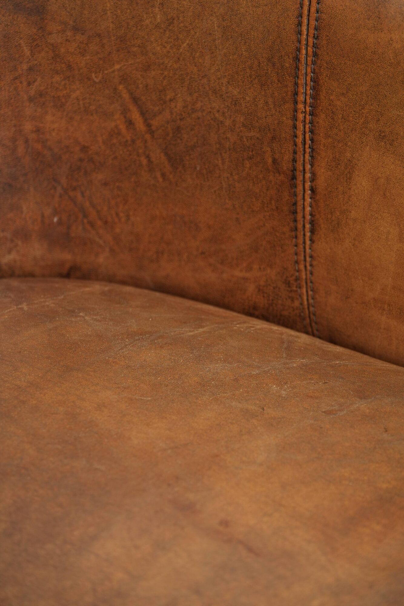 Sheepskin club armchair in a brown colour finished with decorative nails