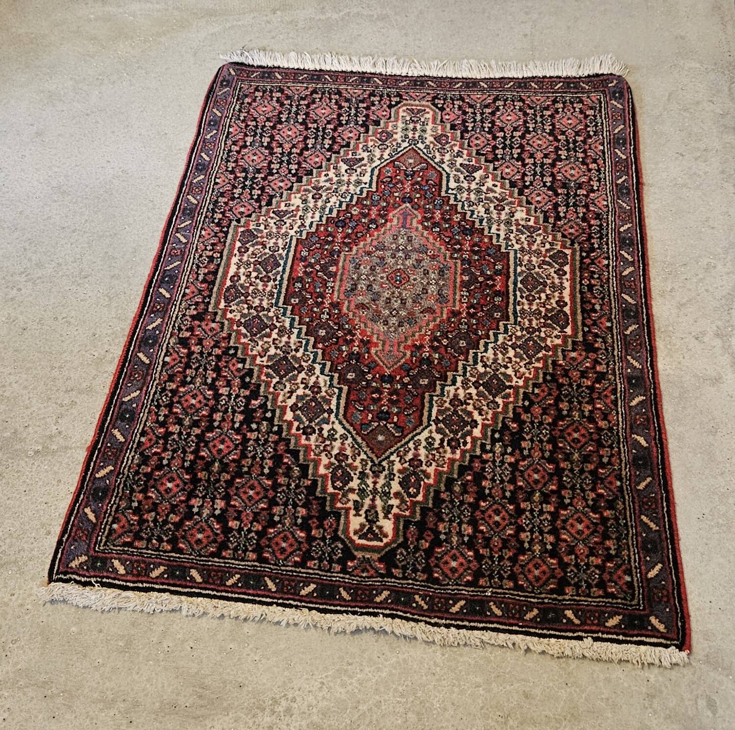 Ancient Persian carpet, wool, red tones, hand-knotted.