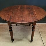Old round table with folding shutters on casters in solid wood in very good condition