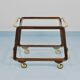May include: A mid-century modern bar cart with a dark wood frame and two c