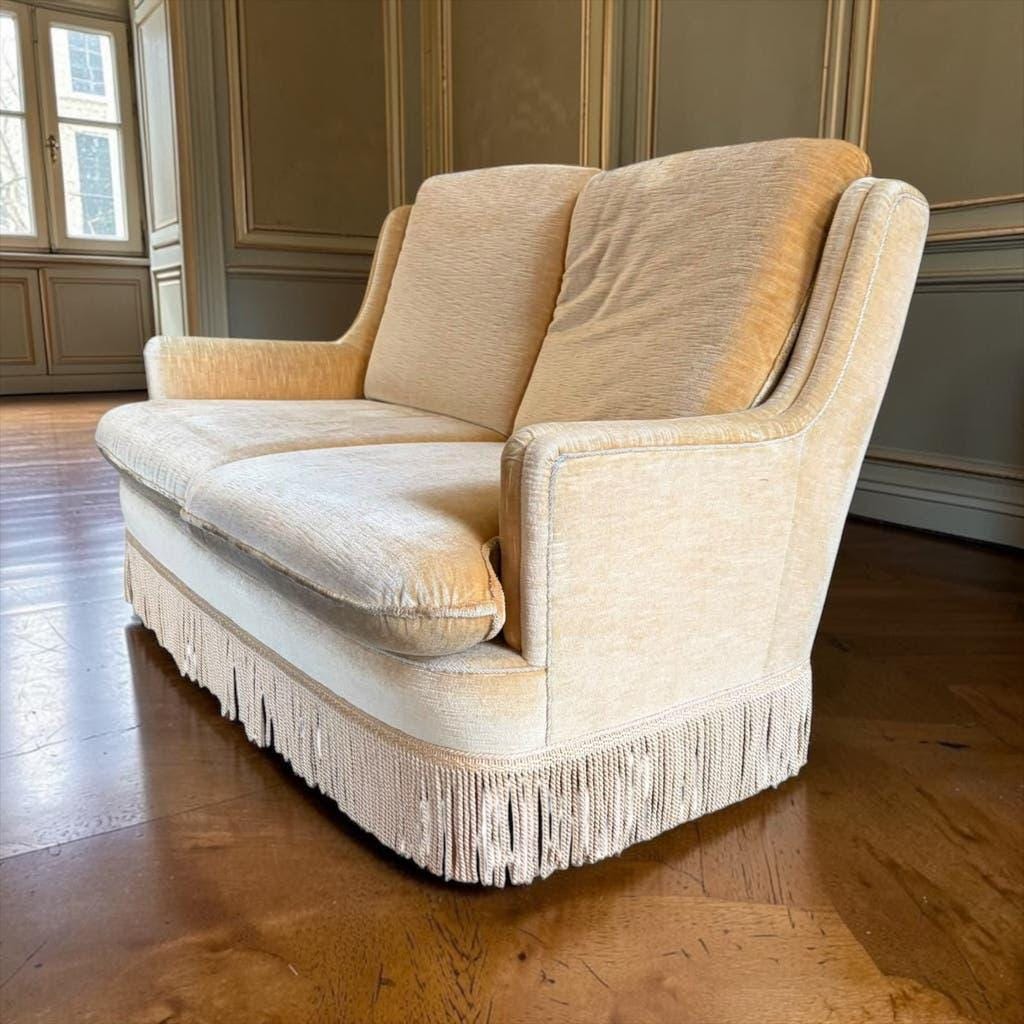 Vintage beige two-seater sofa with fringes
