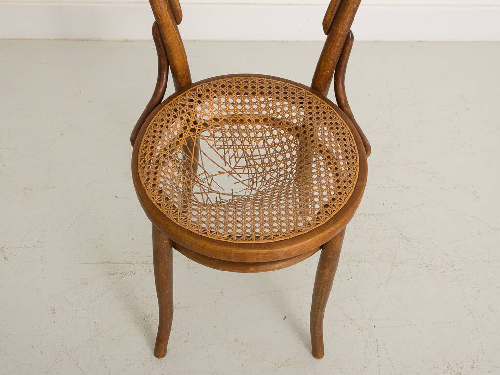 Bistro chair with curved wooden armrests and canning seat