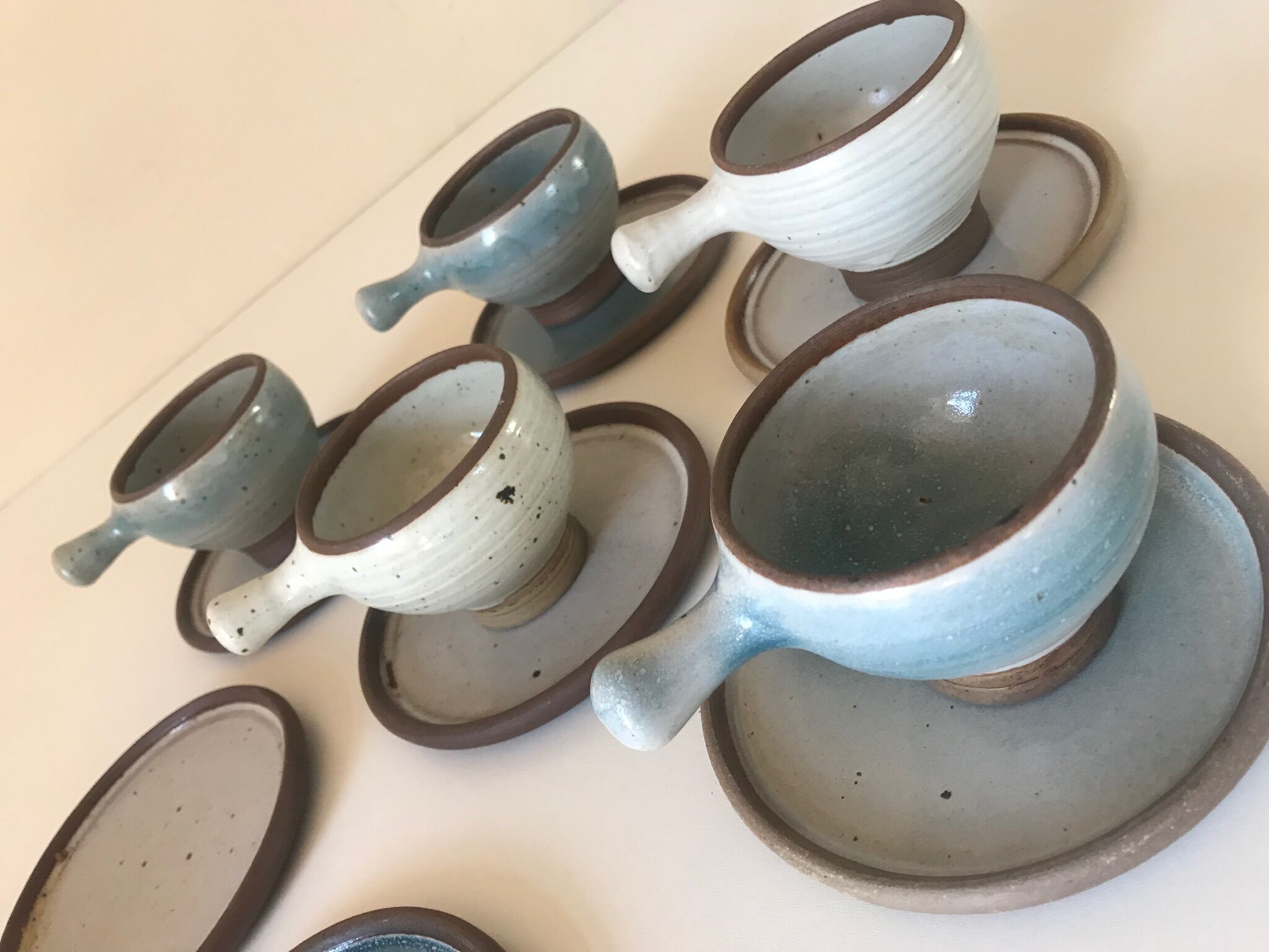 Lot 7 cups and saucers sandstone by Roger Jacques