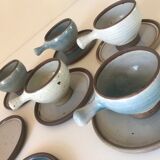 Lot 7 cups and saucers sandstone by Roger Jacques