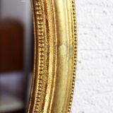 Golden oval mirror with leaf