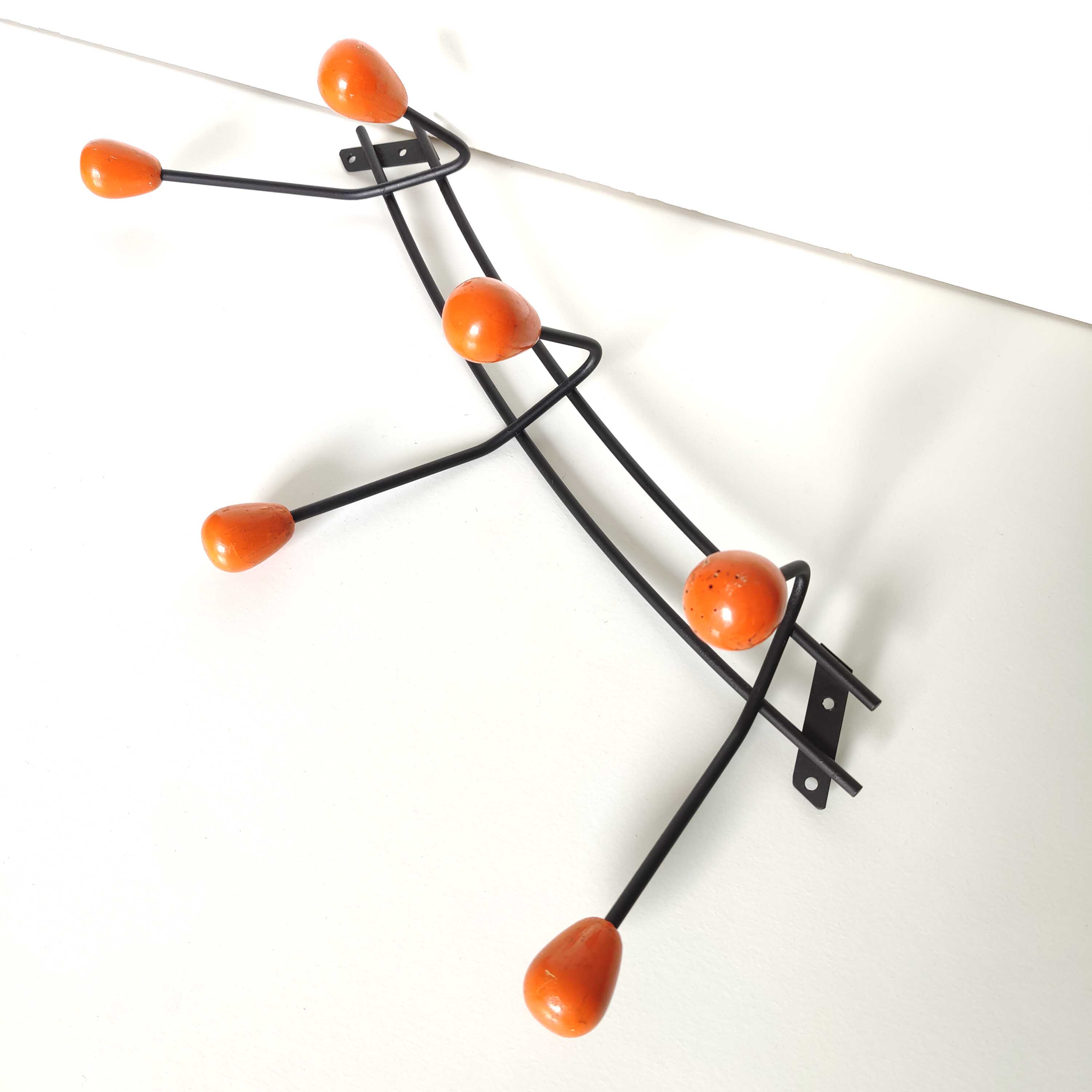 Black metal coat rack and orange wood balls