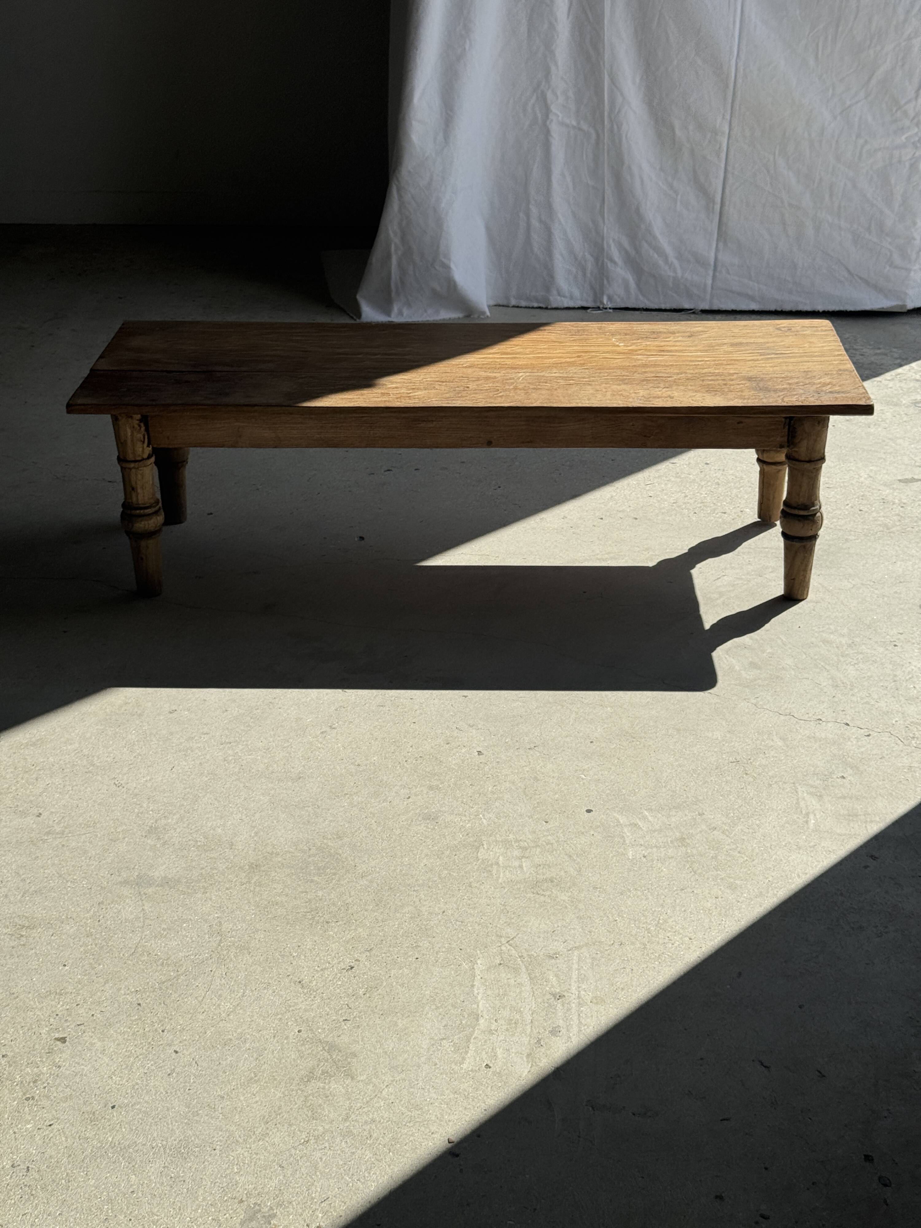 Brown Indonesian teak coffee table, with a border and cylindrical legs H40 L103.