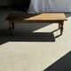 Brown Indonesian teak coffee table, with a border and cylindrical legs H40 L103.