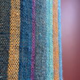 "Stoneware Bottle Lamp" with a multicoloured blue lampshade handwoven in India.