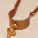 Old bronze or brass fireplace clamp