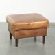 Cowhide ottoman with a beautiful patina finished with decorative nails