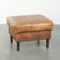 Cowhide ottoman with a beautiful patina finished with decorative nails