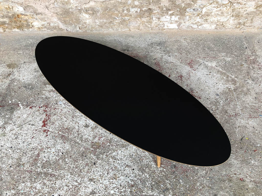 Oval coffee table with a black tray and oak-turned feet
