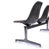 Tandem bench with brown Naugahyde pad shell chairs by Charles and Ray Eames for Herman Miller