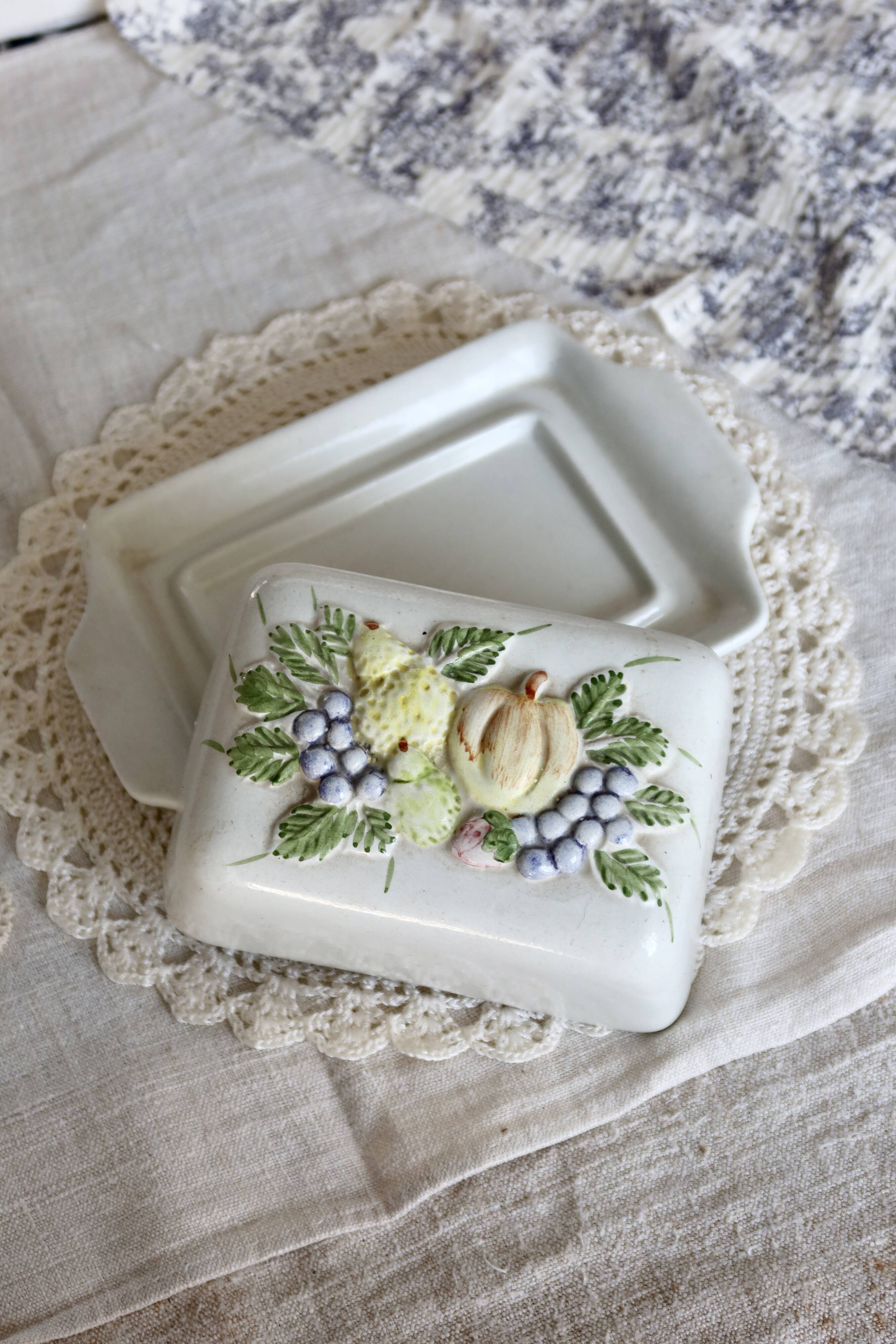 Large vintage faience butter dish with a fruit motif.