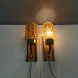 A set of wall lamps in teak wood, with amber colored glass