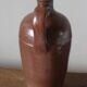 Vintage stoneware liqueur bottle with handle and spout.